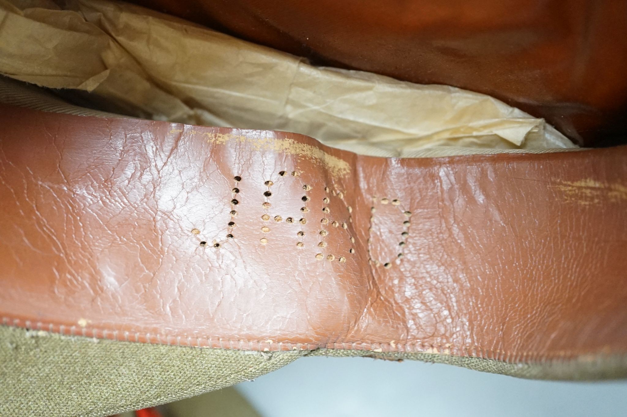 Two army officers' caps in brown leather hat box.